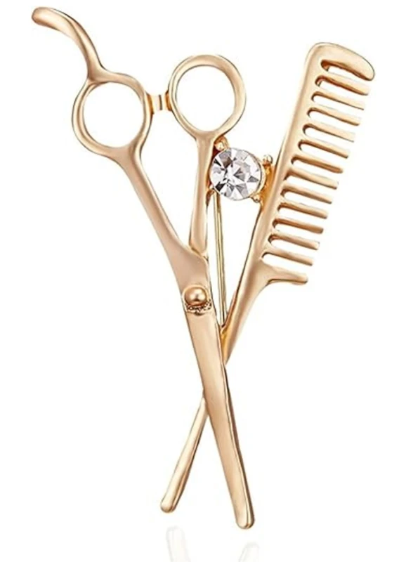 Zelta piespraude ar šķērēm un dekoratīvu friziera ķemmi